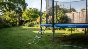 Side profile of a round trampoline with ladder for young children showing proper ground clearance.