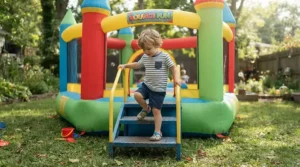 A toddler safely using the non-slip platform on a round trampoline with ladder for young children.